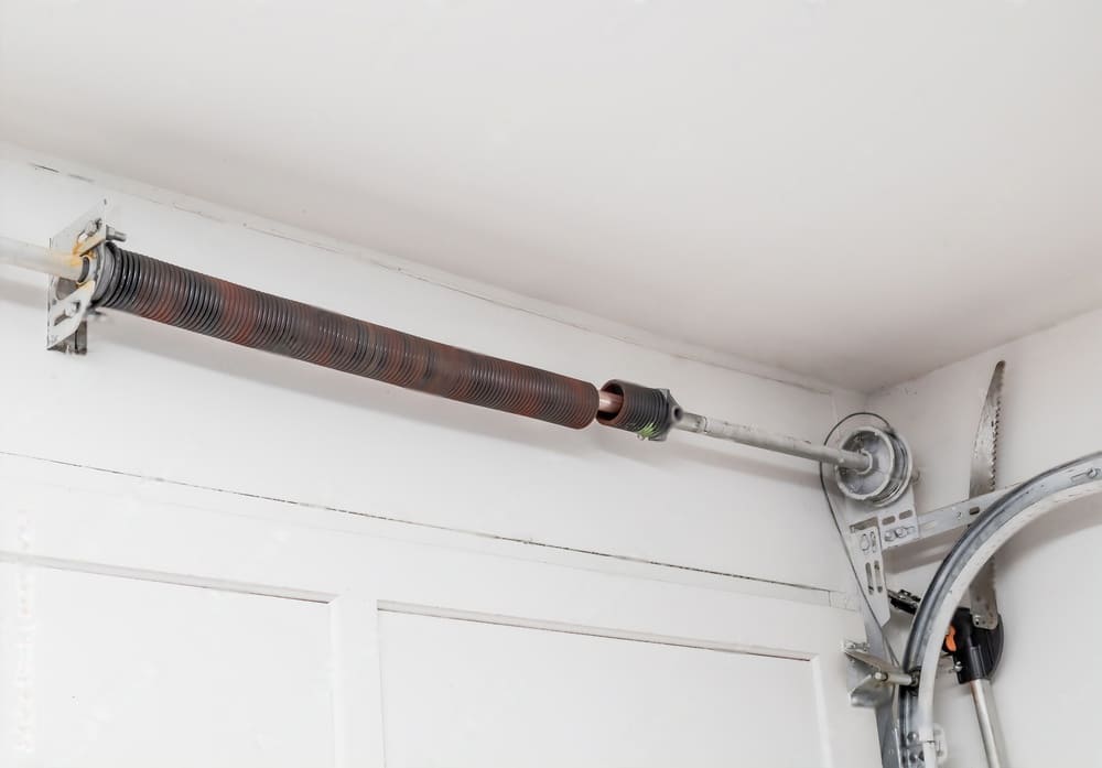 High-tension garage door torsion spring and cable drum assembly requiring professional repair in Austin, Texas